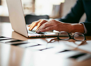 Blue light blocking glasses placed next to a laptop screen for digital protection
